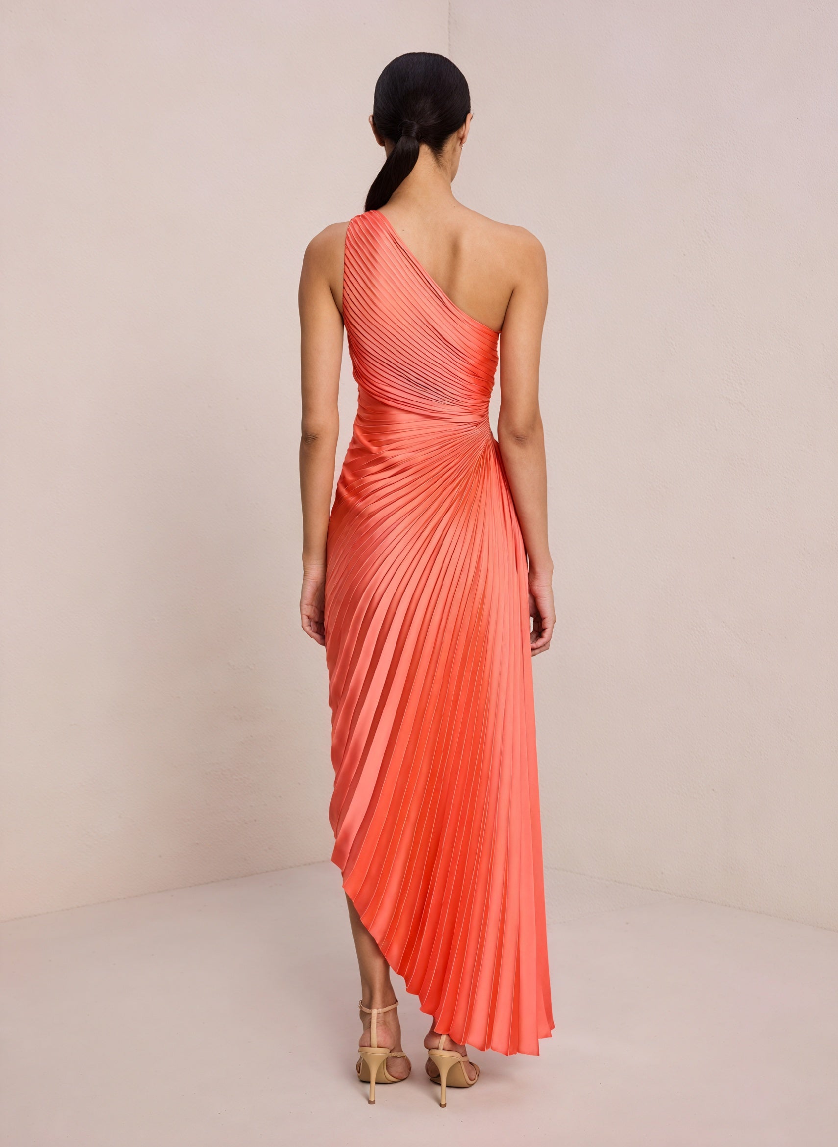 Cream monospalla plissettato dress with asymmetrical hem from Montaracrest, showcased on a hanger.