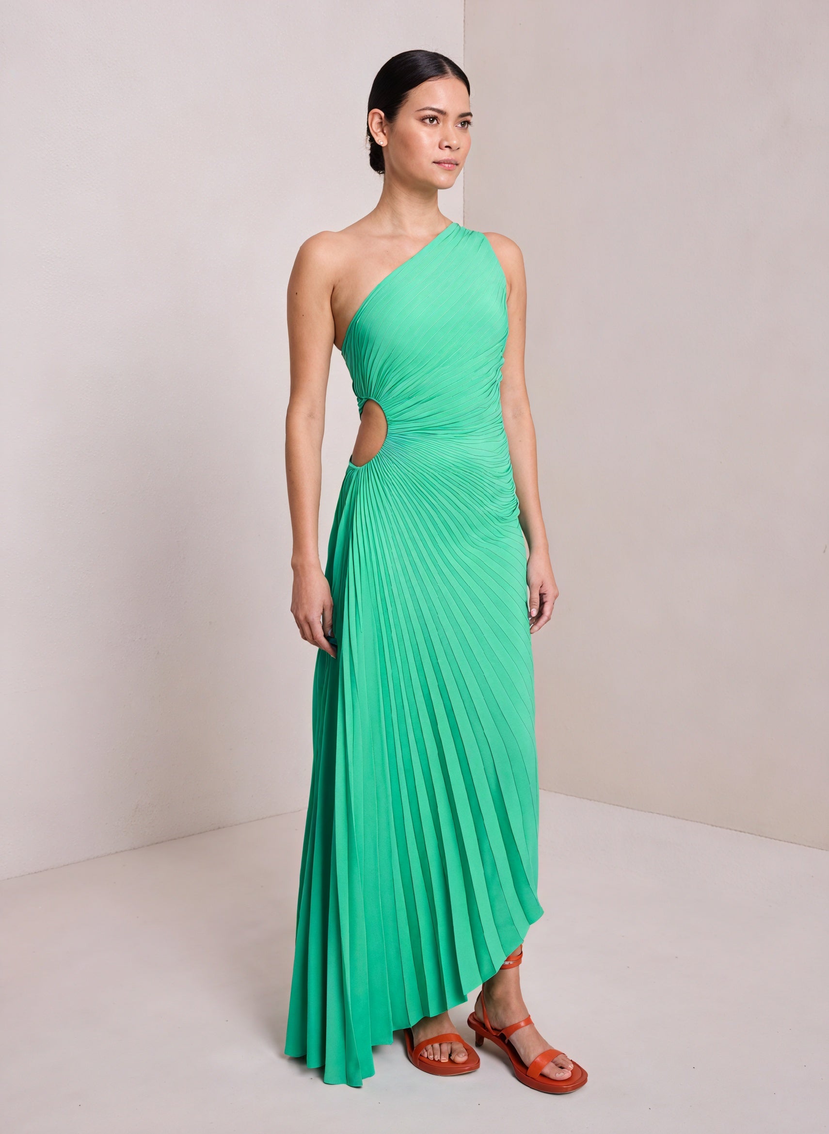 White monospalla pleated dress with asymmetric hem from Montaracrest showcasing its elegant design and flowing fabric.