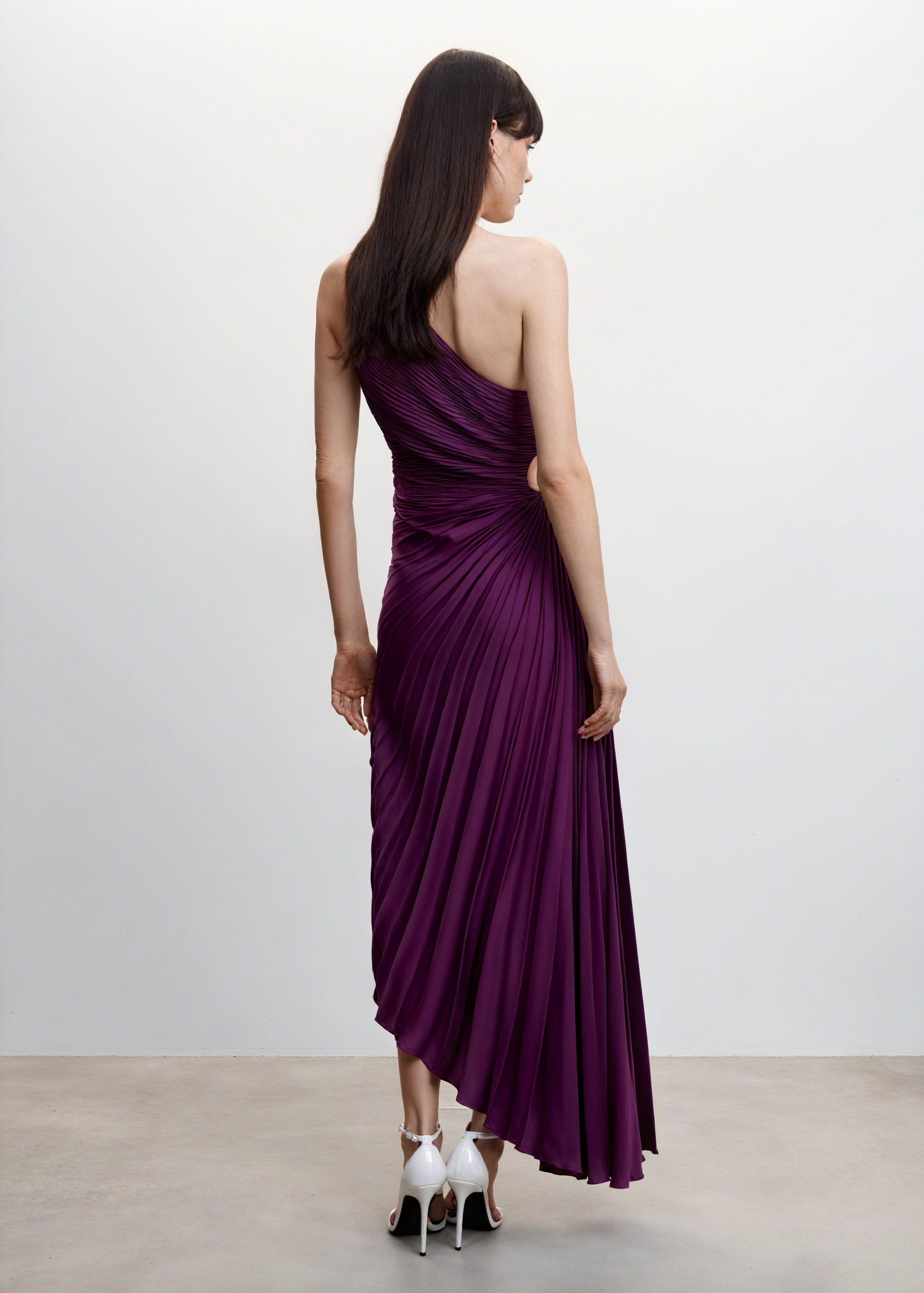 Light pink monospalla pleated dress with asymmetric hem from Montaracrest, featuring a single shoulder design and flowing fabric.