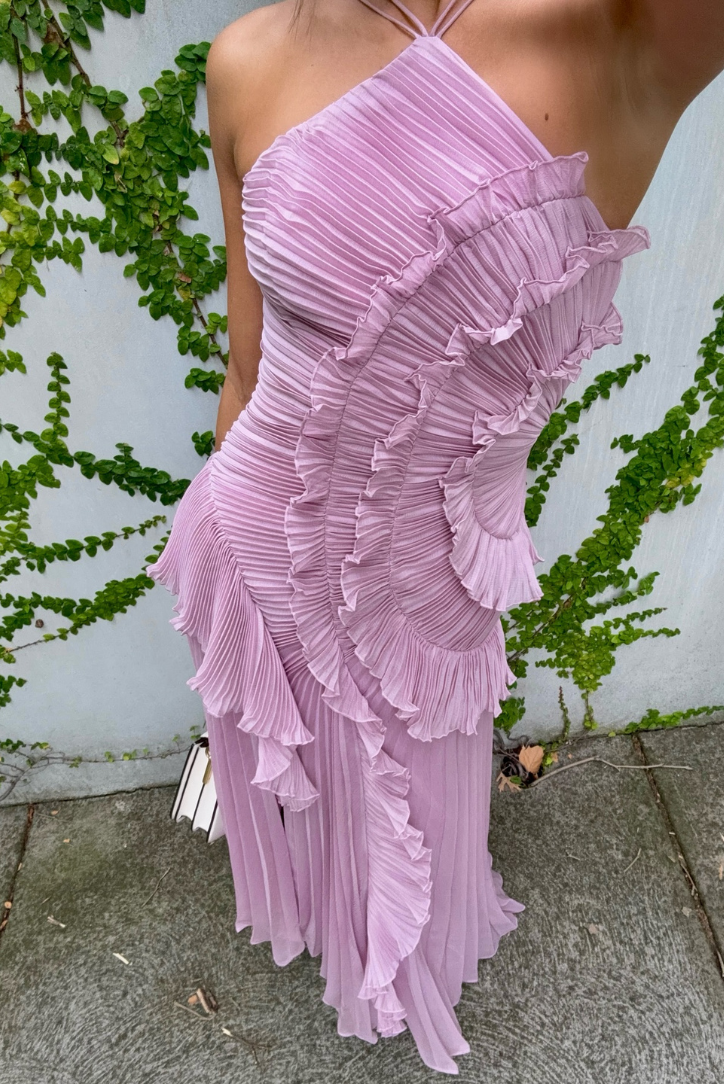 Elegant long pleated dress by Montaracrest with halter neckline and ruffle detail, showcasing a flowy, feminine silhouette.