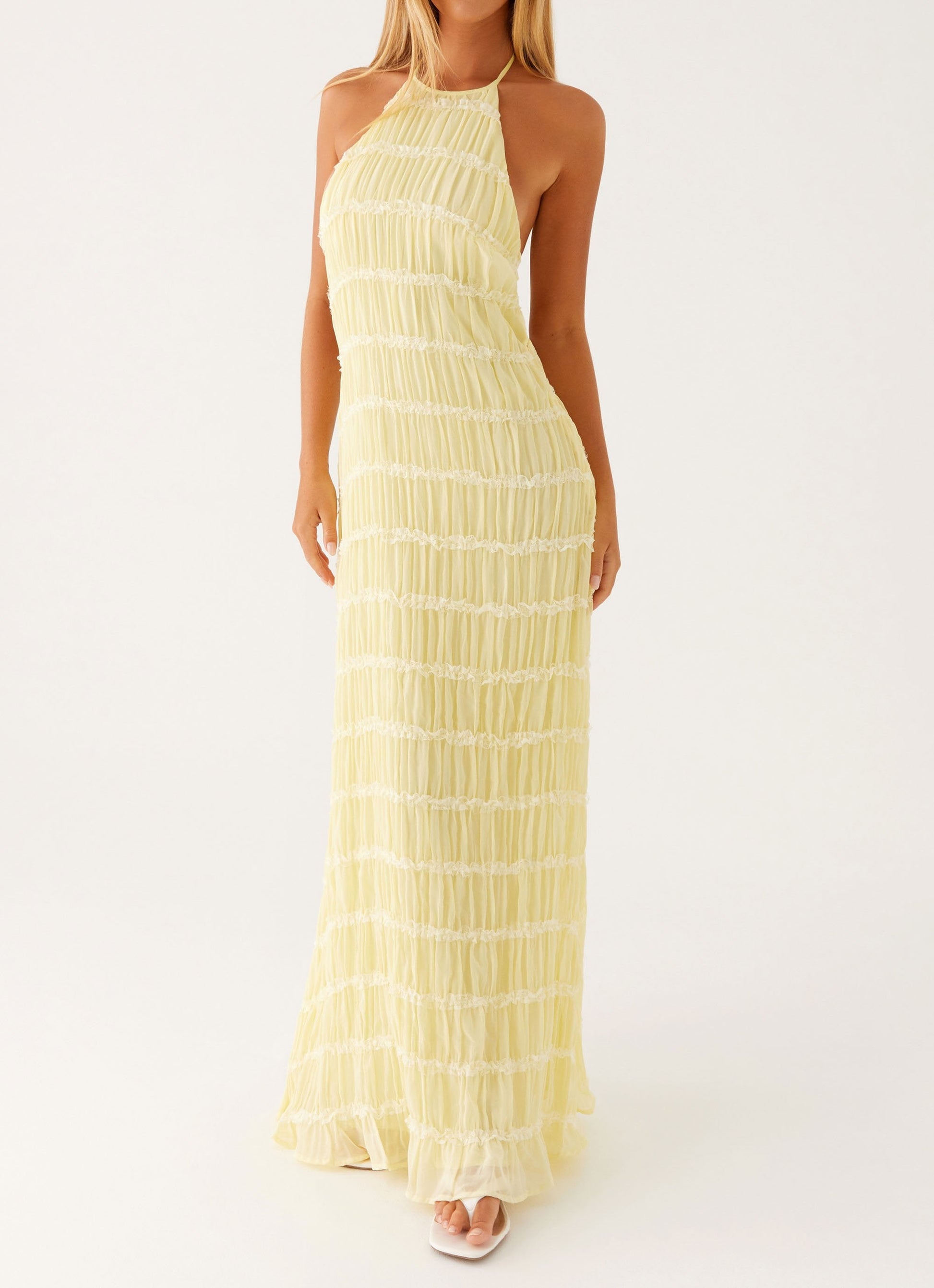 Yellow Celeste Maxi Dress by Montaracrest featuring a flowing silhouette and elegant design, displayed on a hanger.