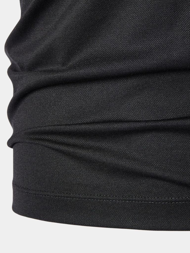 Montaracrest polo shirt with obsidian-colored trim and decorative cross crown detail on a sleek fabric background.