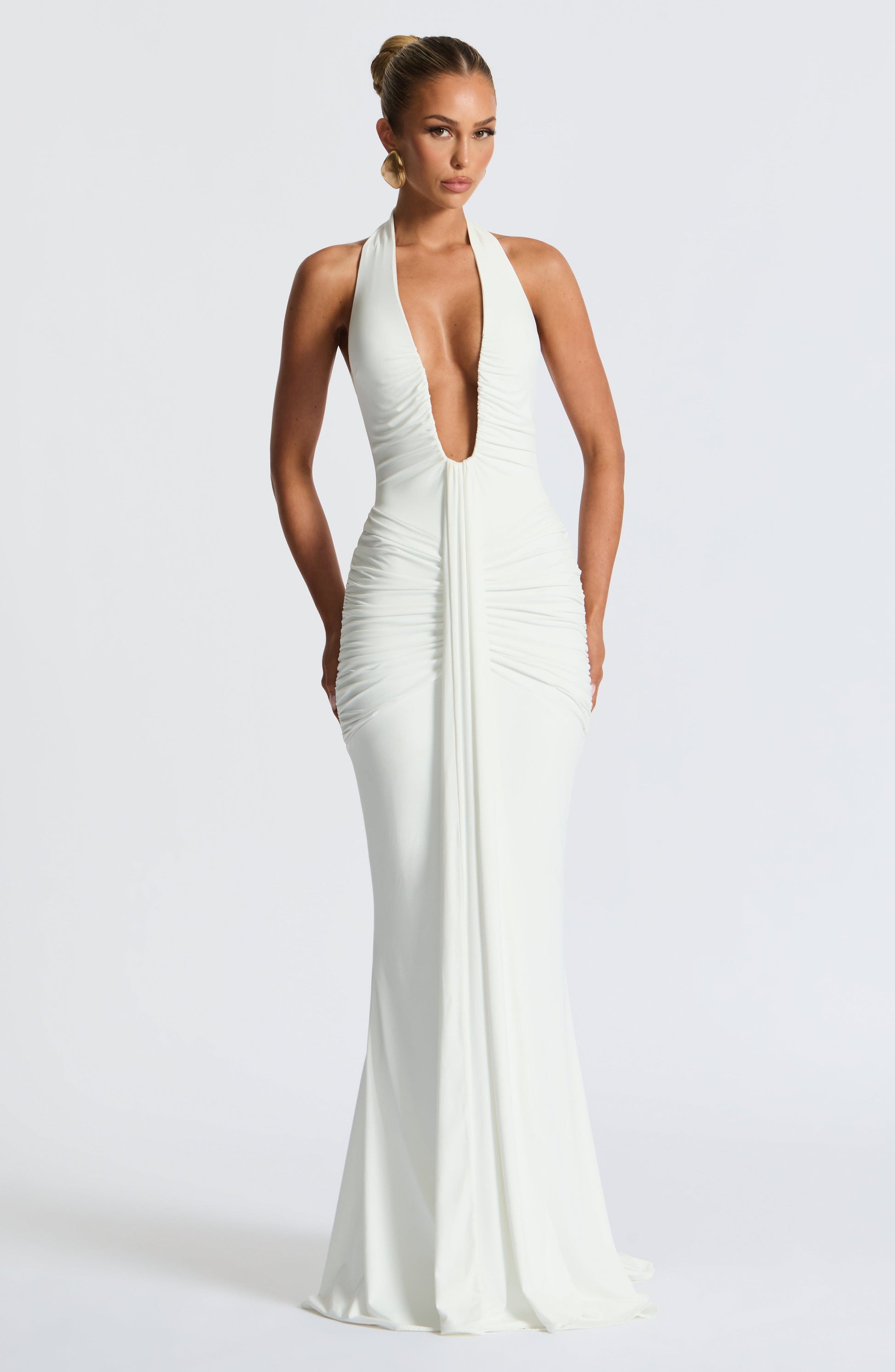 White Freja halterneck dress by Montaracrest, featuring a maxi length and elegant design, shown on a model.